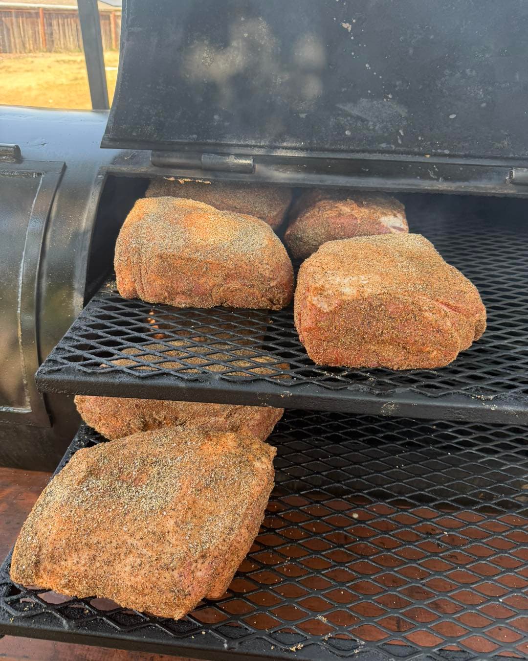 Smoked meat portions resting on the grate